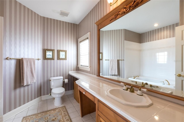 bathroom with tile patterned flooring, vanity, toilet, and a bathing tub