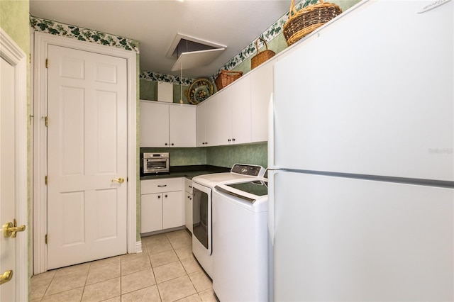 washroom featuring cabinets, light tile patterned floors, and separate washer and dryer