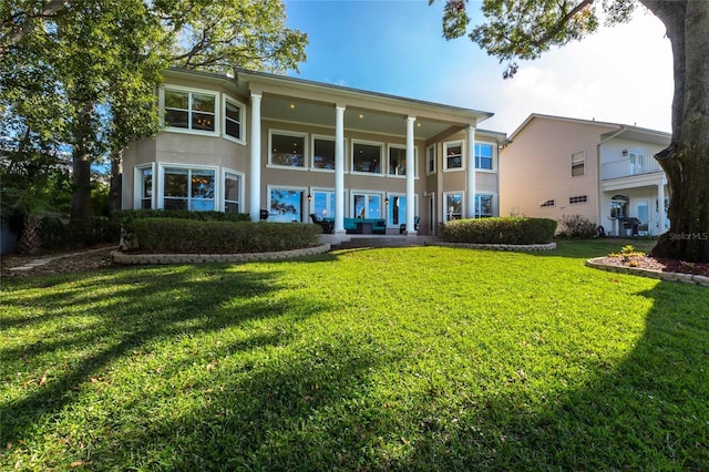 rear view of house featuring a yard and a porch