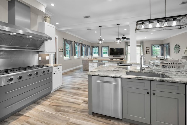 kitchen featuring gray cabinetry, light stone counters, white cabinets, and ventilation hood