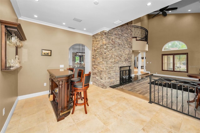 dining area with ceiling fan, ornamental molding, and a fireplace