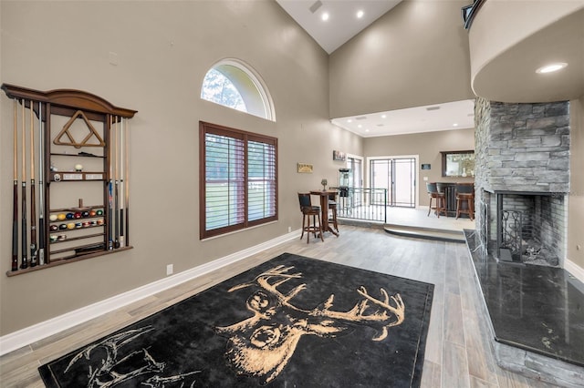 entrance foyer featuring wood-type flooring, a fireplace, and high vaulted ceiling