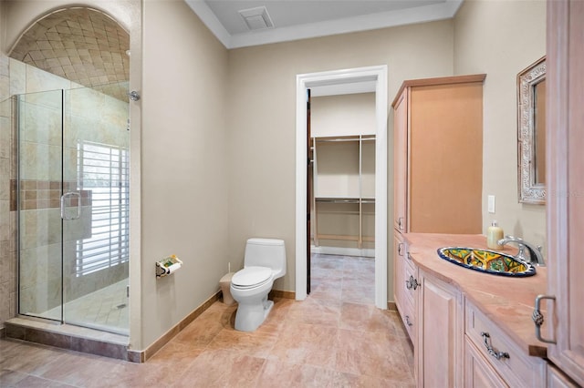 bathroom with vanity, ornamental molding, an enclosed shower, and toilet