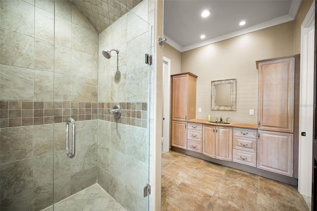 bathroom with vanity, a shower with shower door, and ornamental molding