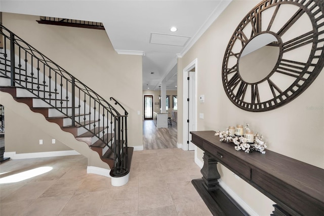 tiled entrance foyer featuring crown molding