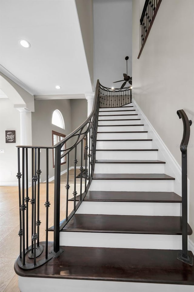 stairs with crown molding and decorative columns