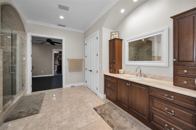 bathroom with ceiling fan, vanity, a shower with shower door, and ornamental molding