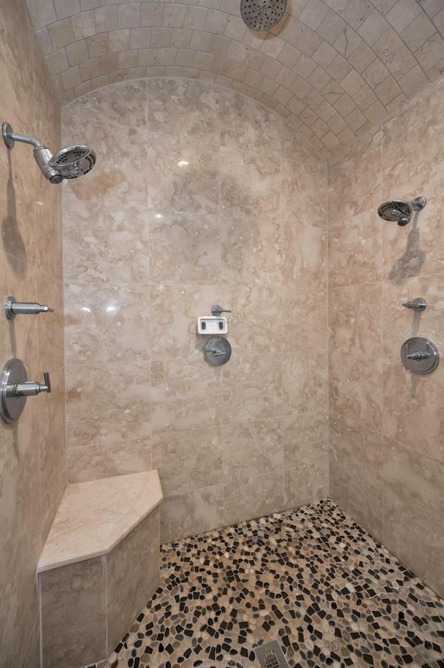 bathroom featuring a tile shower and brick ceiling