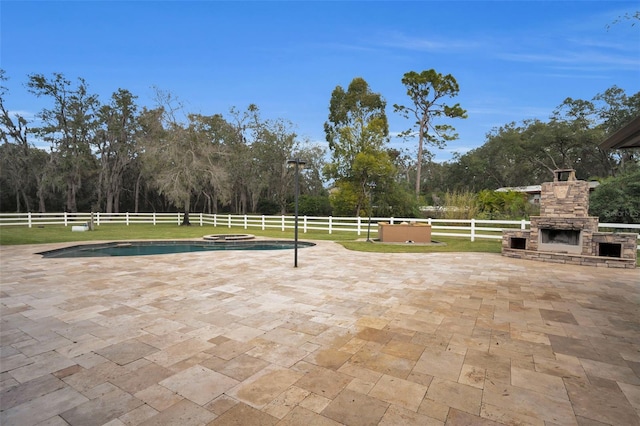 view of patio / terrace with a fenced in pool and an outdoor stone fireplace