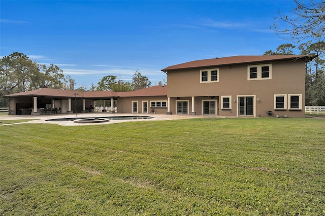 rear view of house with a lawn and a patio