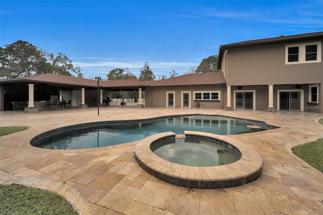 view of swimming pool featuring an in ground hot tub and a patio