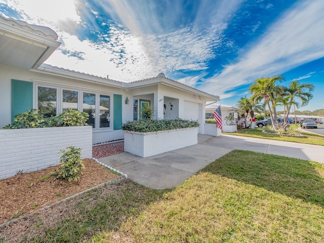 view of front of property featuring a garage and a front lawn