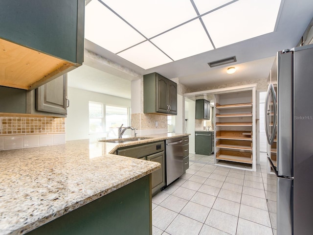 kitchen featuring stainless steel appliances, tasteful backsplash, sink, and light tile patterned floors