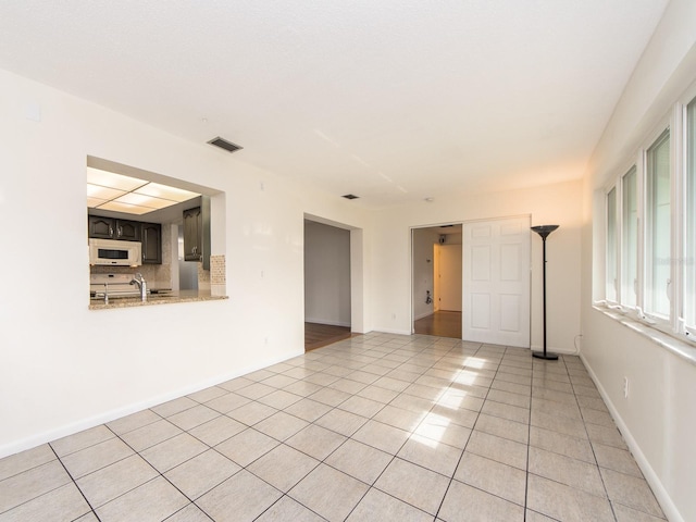 spare room featuring light tile patterned floors and sink