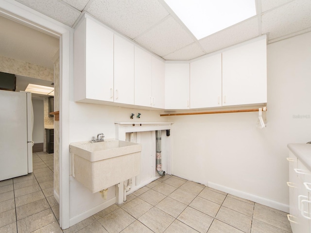 laundry room featuring light tile patterned flooring and sink