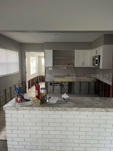 kitchen featuring tile patterned flooring, white cabinetry, and kitchen peninsula