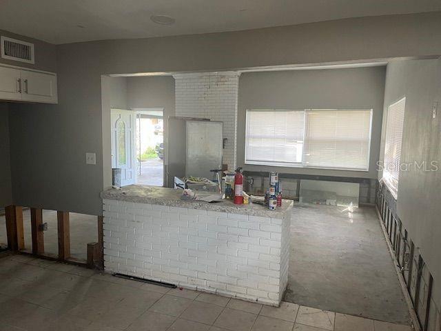 kitchen featuring kitchen peninsula, white cabinetry, and light tile patterned flooring