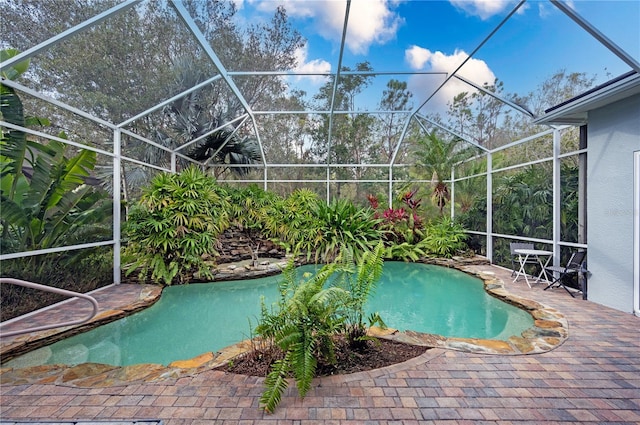 view of swimming pool featuring glass enclosure