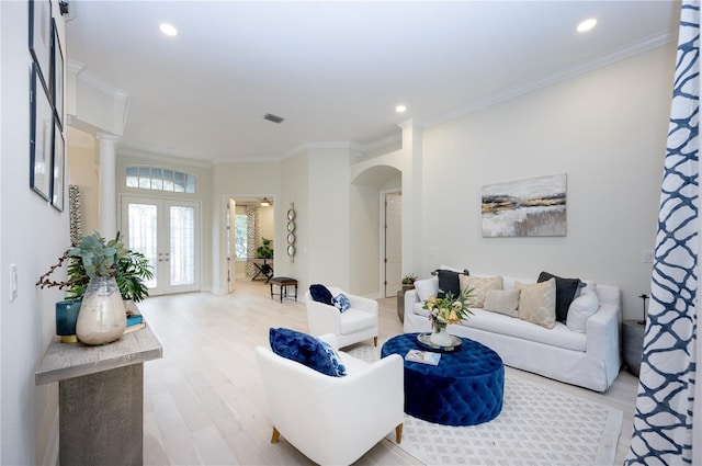 living room featuring french doors, light hardwood / wood-style flooring, and crown molding