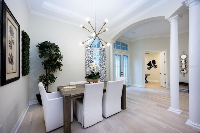 dining area with a notable chandelier, light hardwood / wood-style floors, ornamental molding, and french doors