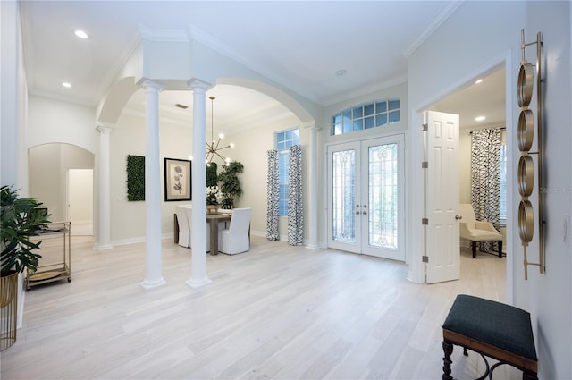 entryway with a chandelier, french doors, light wood-type flooring, and ornamental molding