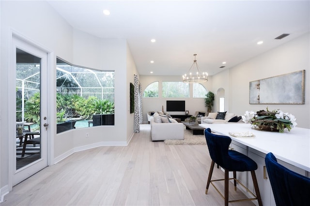 living room featuring light hardwood / wood-style floors and an inviting chandelier