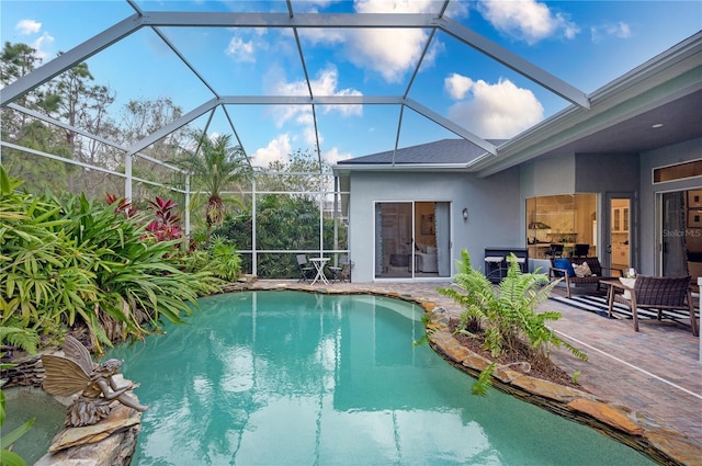 view of swimming pool featuring glass enclosure and a patio