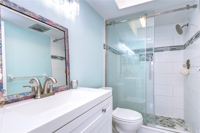 bathroom featuring vanity, an enclosed shower, and toilet