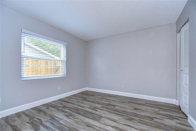 unfurnished room featuring a textured ceiling and hardwood / wood-style floors