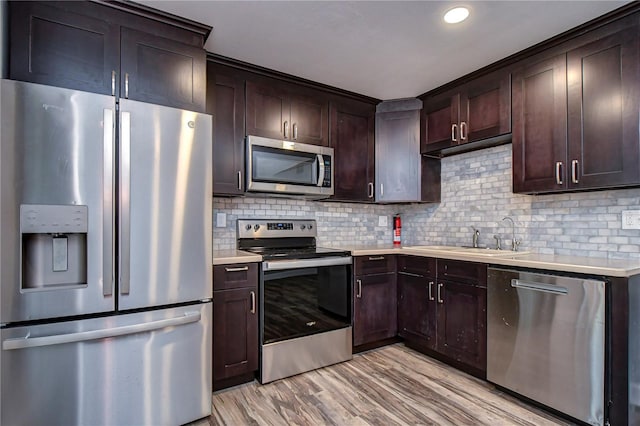 kitchen featuring decorative backsplash, sink, light hardwood / wood-style flooring, stainless steel appliances, and dark brown cabinets