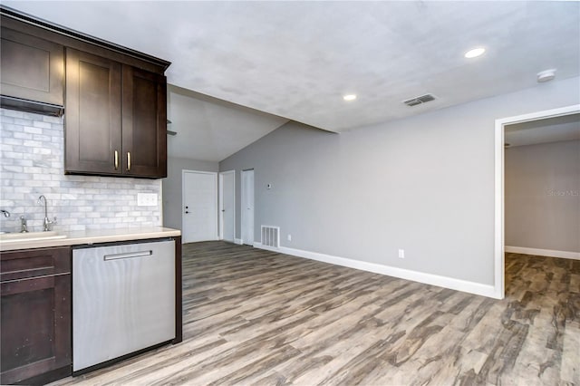 kitchen featuring decorative backsplash, light wood-type flooring, dark brown cabinets, dishwasher, and sink