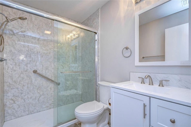 bathroom featuring toilet, a shower with door, and vanity