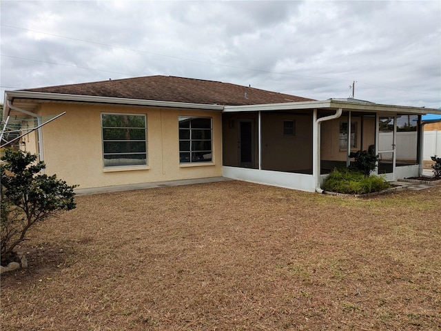 back of property featuring a sunroom and a yard