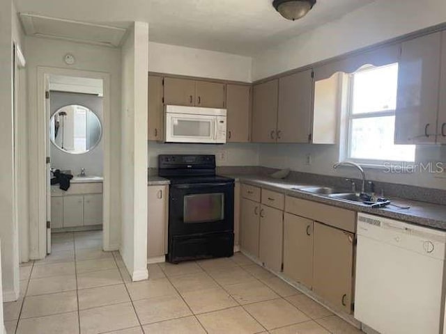 kitchen featuring sink, light tile patterned floors, and white appliances