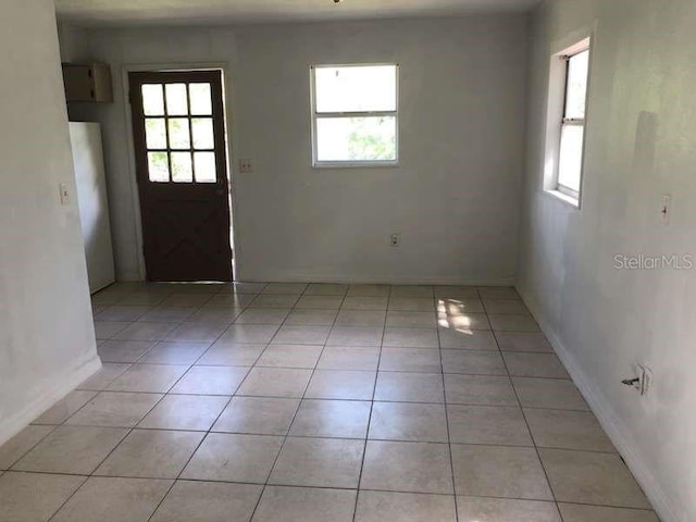 spare room featuring light tile patterned flooring and a wealth of natural light