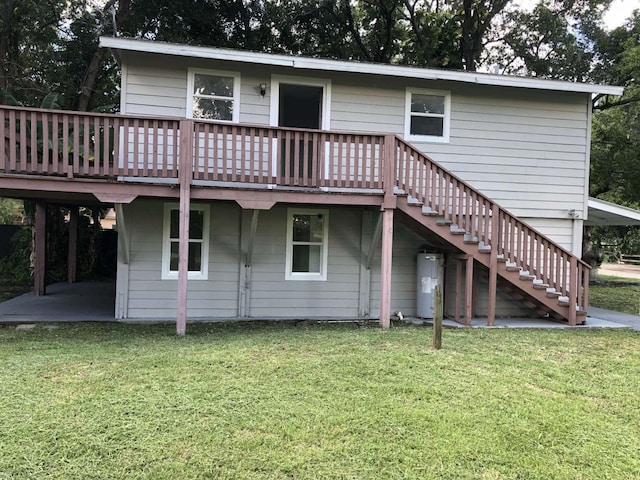 rear view of property with a lawn, electric water heater, and a wooden deck