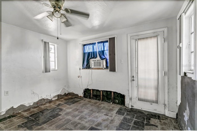 unfurnished room with a textured ceiling, ceiling fan, and cooling unit