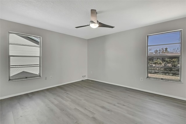 unfurnished room with a textured ceiling, hardwood / wood-style flooring, and ceiling fan