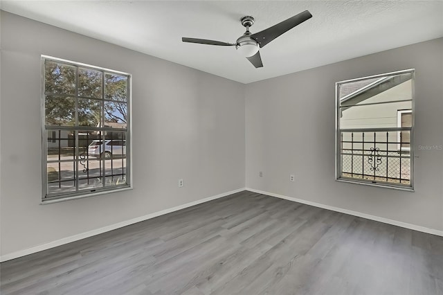 empty room with hardwood / wood-style floors and ceiling fan