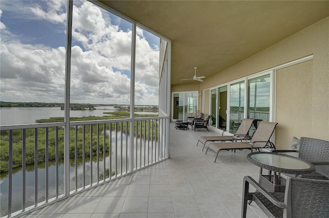 balcony featuring ceiling fan and a water view