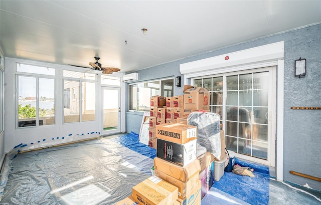 sunroom / solarium with a wall mounted AC and ceiling fan