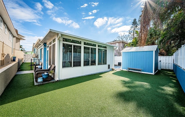 rear view of property featuring a storage shed and a lawn