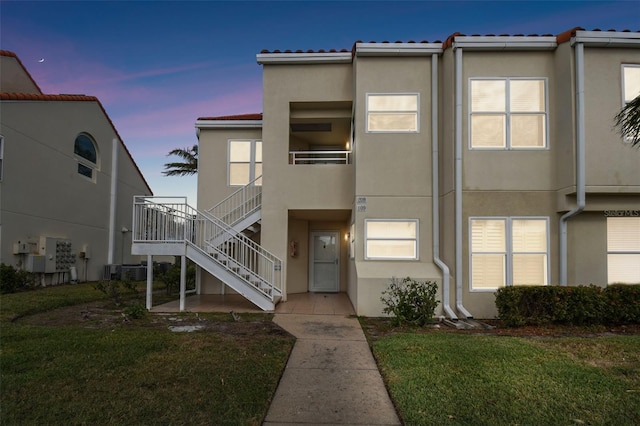 view of front facade featuring a lawn and central AC unit