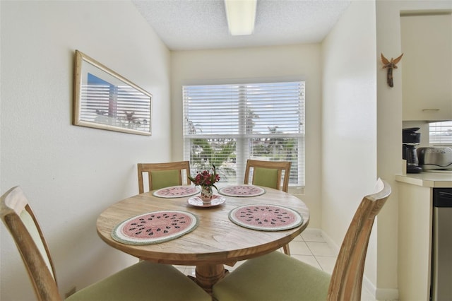 dining area featuring light tile patterned floors and a textured ceiling