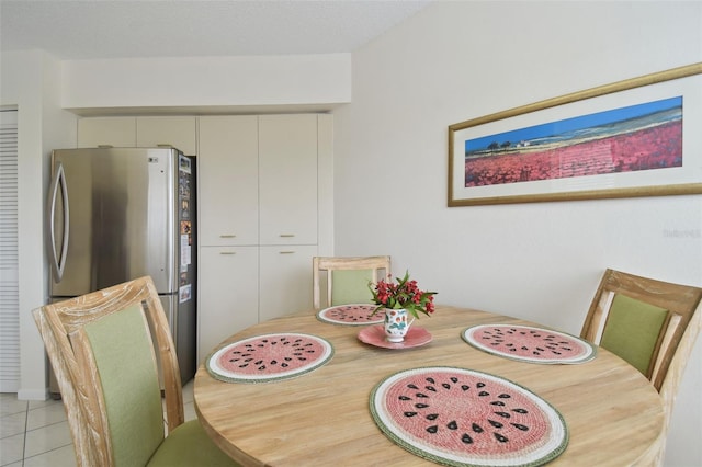 dining space with light tile patterned flooring and a textured ceiling