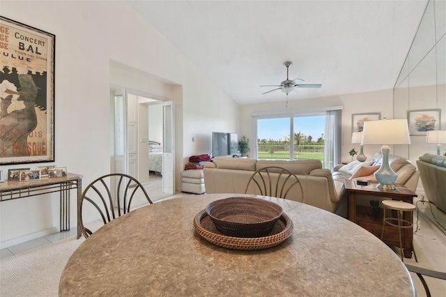 dining area with light tile patterned floors, ceiling fan, and lofted ceiling