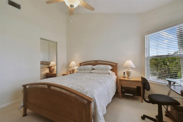 bedroom featuring a closet, light colored carpet, and ceiling fan