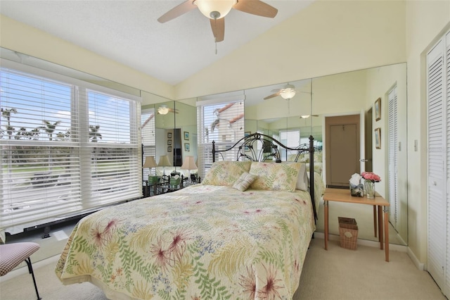 bedroom featuring ceiling fan, a closet, light colored carpet, and vaulted ceiling