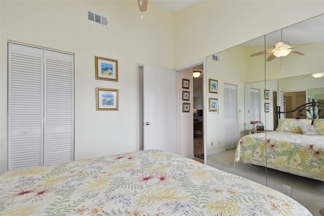 bedroom featuring a towering ceiling, ceiling fan, and multiple closets