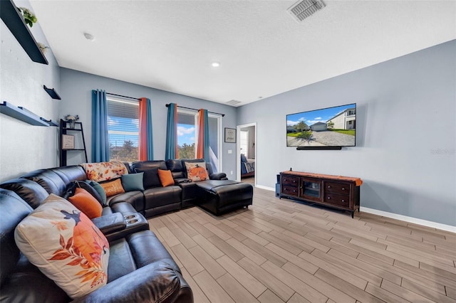 living room featuring light hardwood / wood-style floors and a textured ceiling